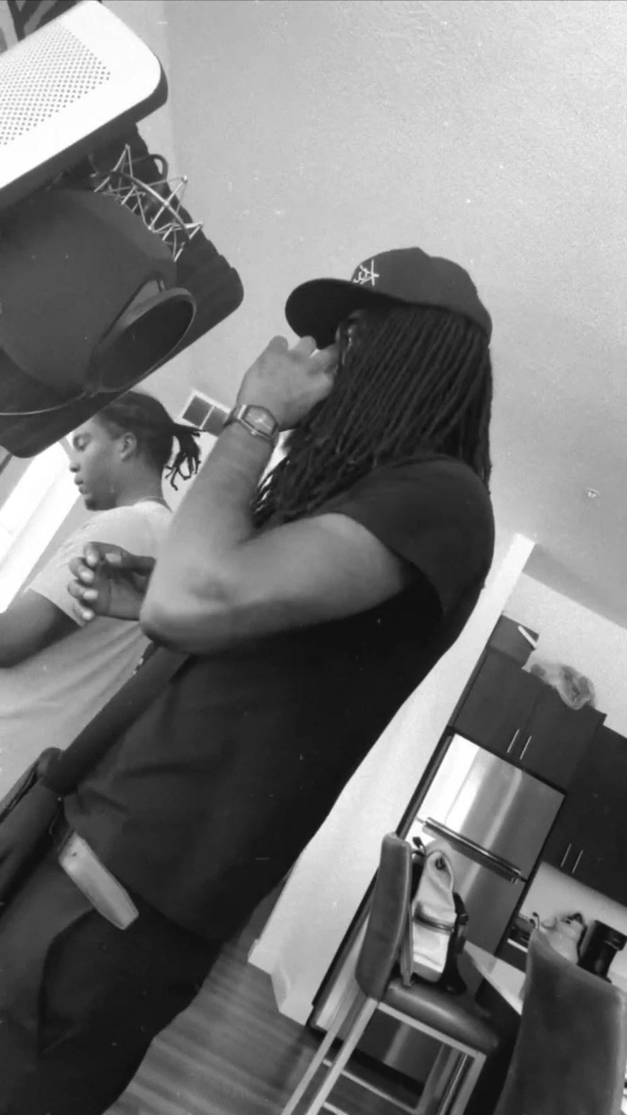 Black and white frame of Cubano Jayy taking a call before a session
