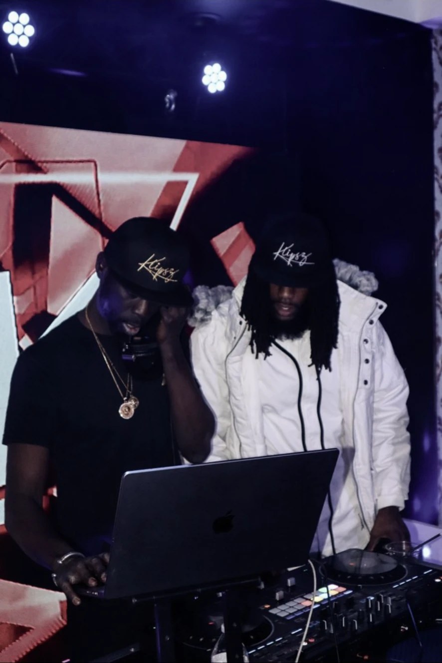 Cubano Jayy and a DJ working over a laptop and controller during a night set