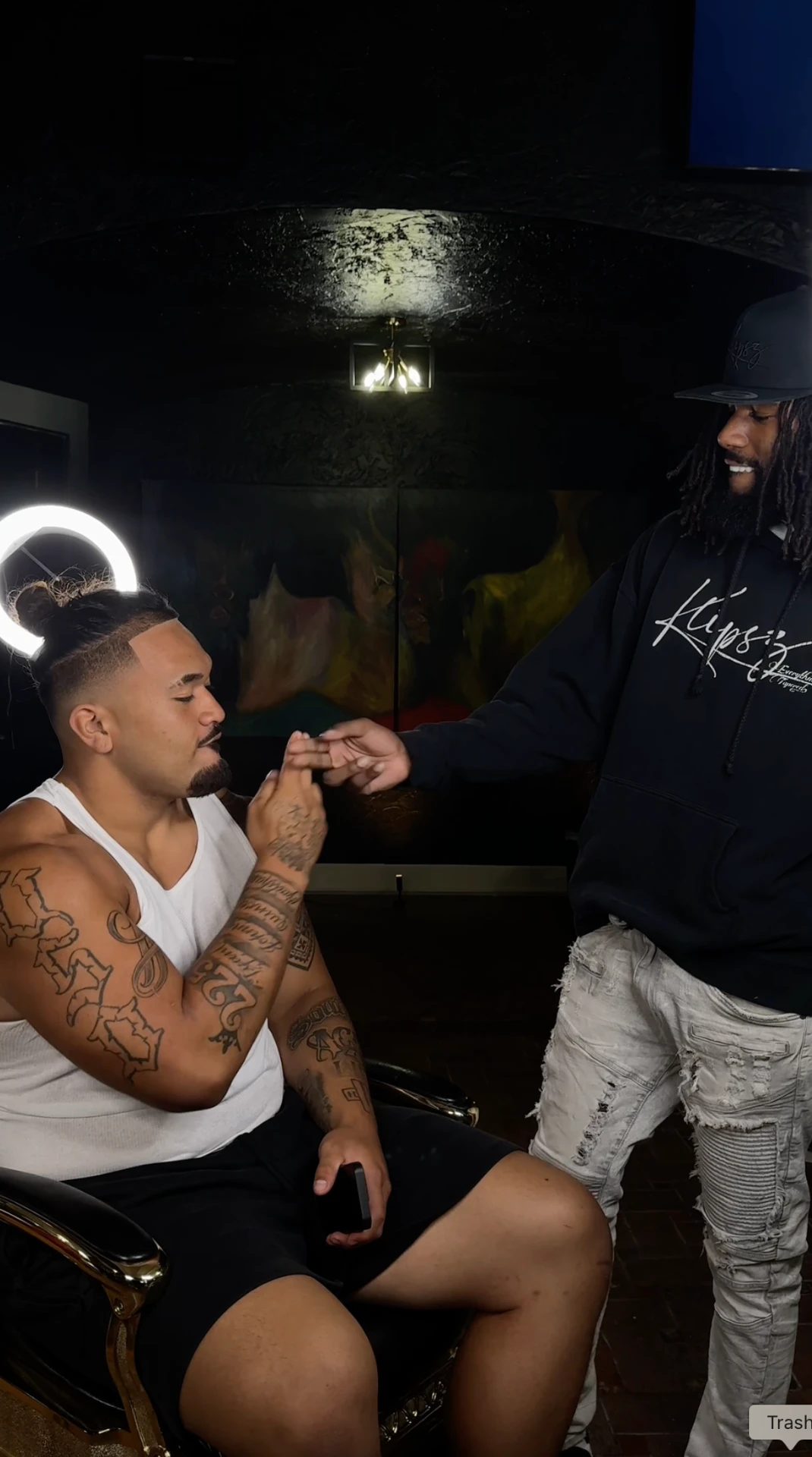 Jayy Klipsz consulting with a client in the chair after a fresh lineup and taper